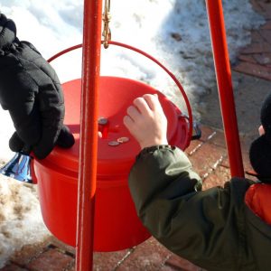Boy donating into red bucket
