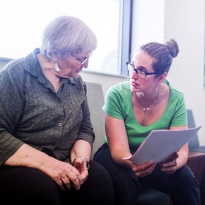 Two women discussing paperwork