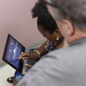 Woman showing coworker something on laptop screen