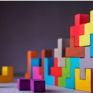 Brightly colored wodden blocks of different shapes on dark background